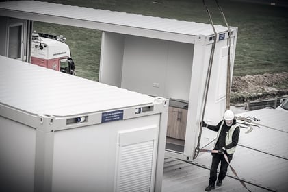 tf-jackson-about-high-angle-shot-of-worker-guiding-modular-building-into-place-during-install