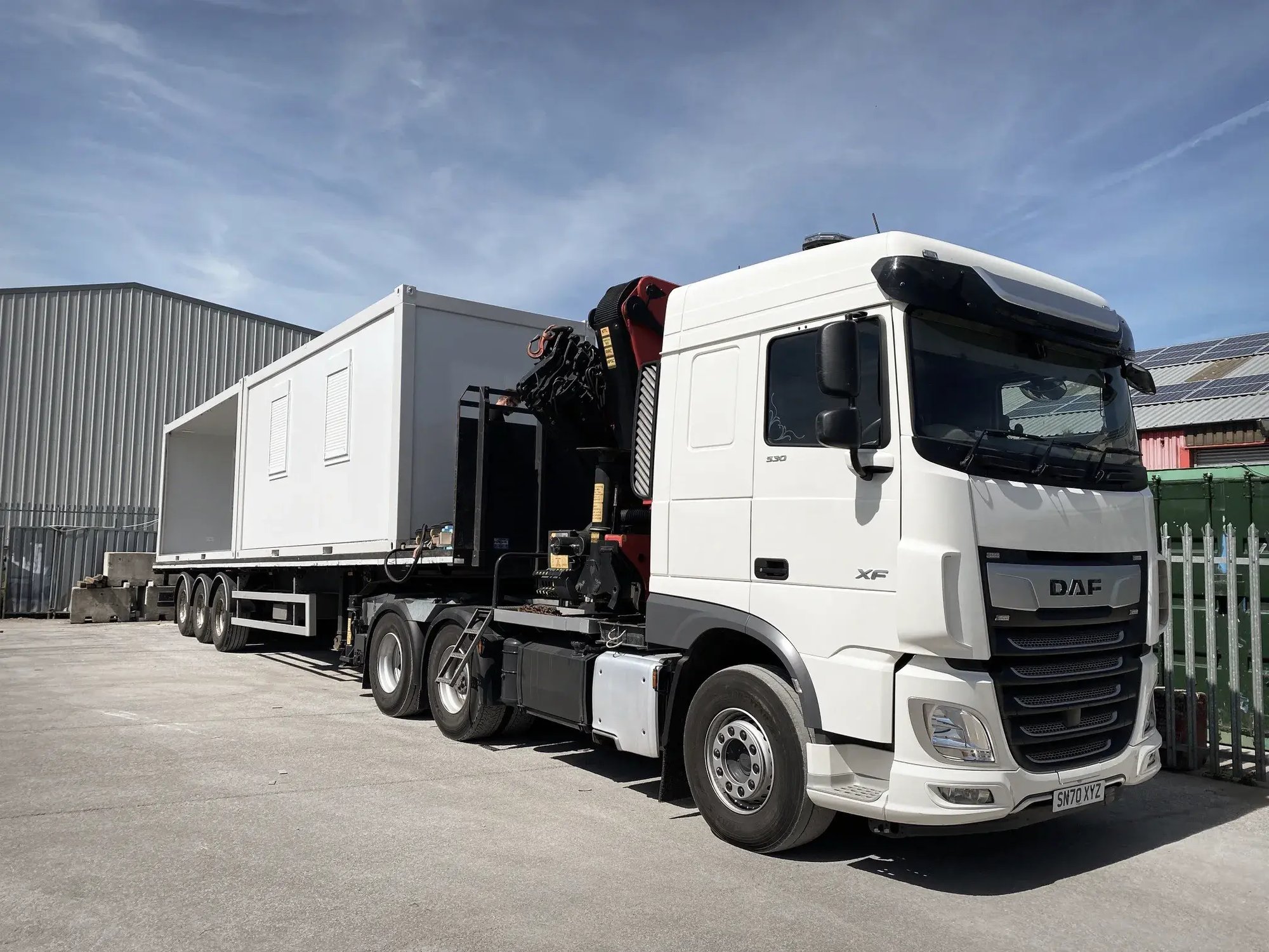 tf-jackson-used-buildings-modern-white-lorry-delivers-large-portable-building